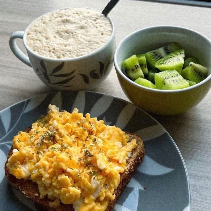 Desayuno real: tostada con huevo revuelto, café con leche y un bowl de kiwi